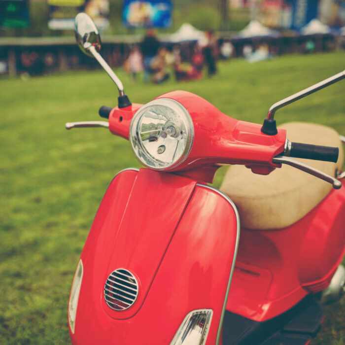Red retro scooter on grass