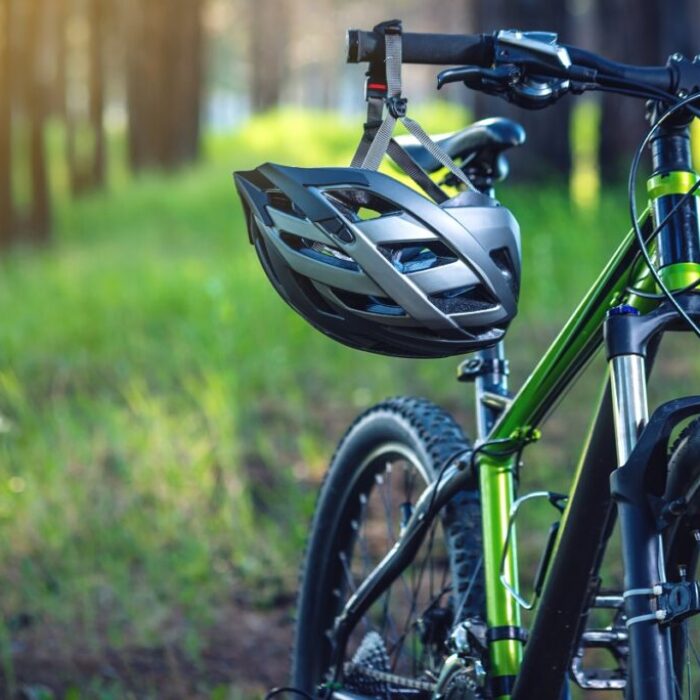 Sports helmet on a green mountain bike in the Park. Concept protection during active and healthy lifestyle