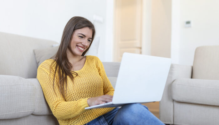 Young woman waving at laptop and talking to her friends via video call, girl student talking by video conference call, female teacher trainer tutoring by webcam, online training, e-coaching concept